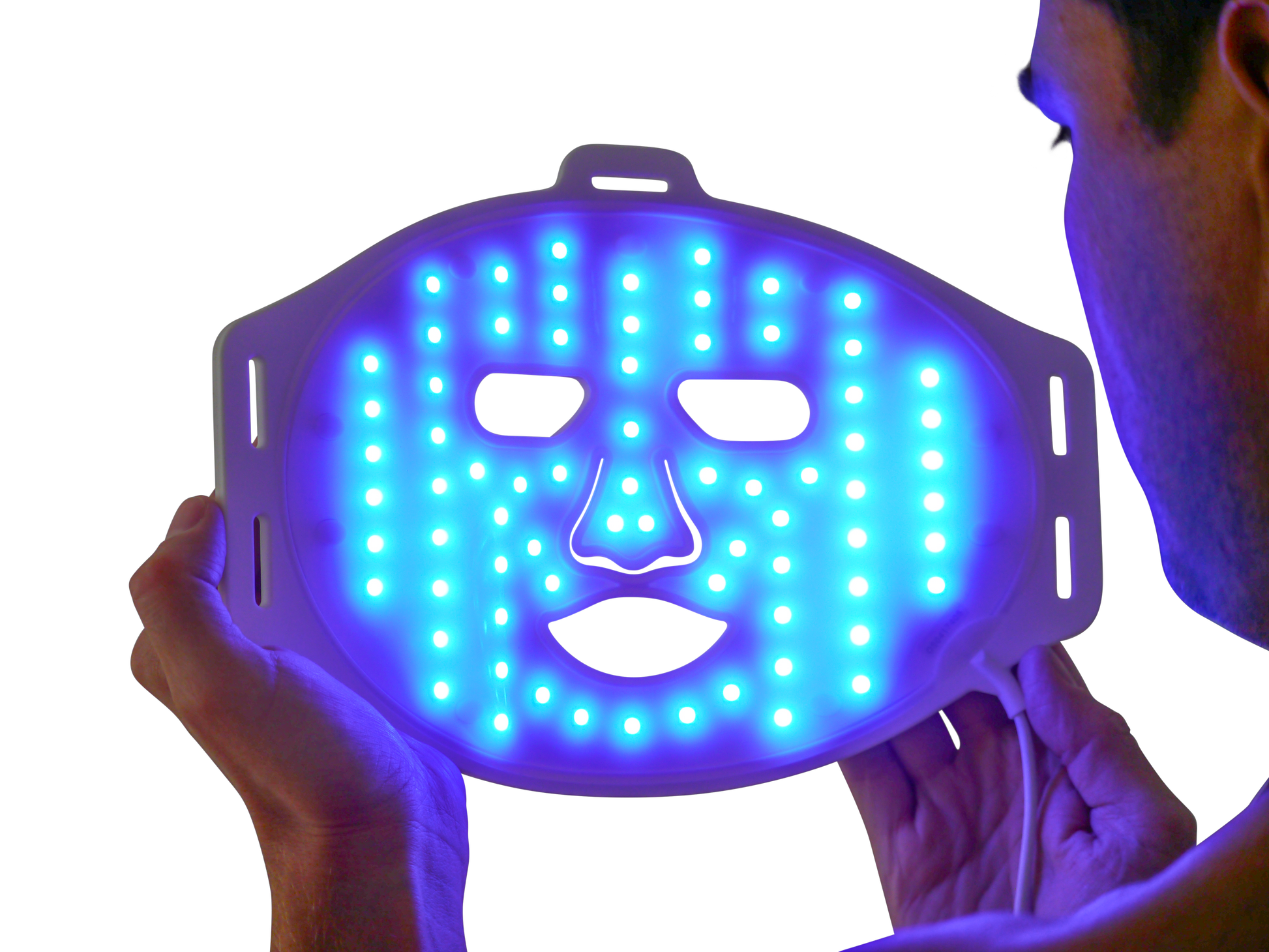 Man holding LED blue light therapy face mask for acne treatment and skin care