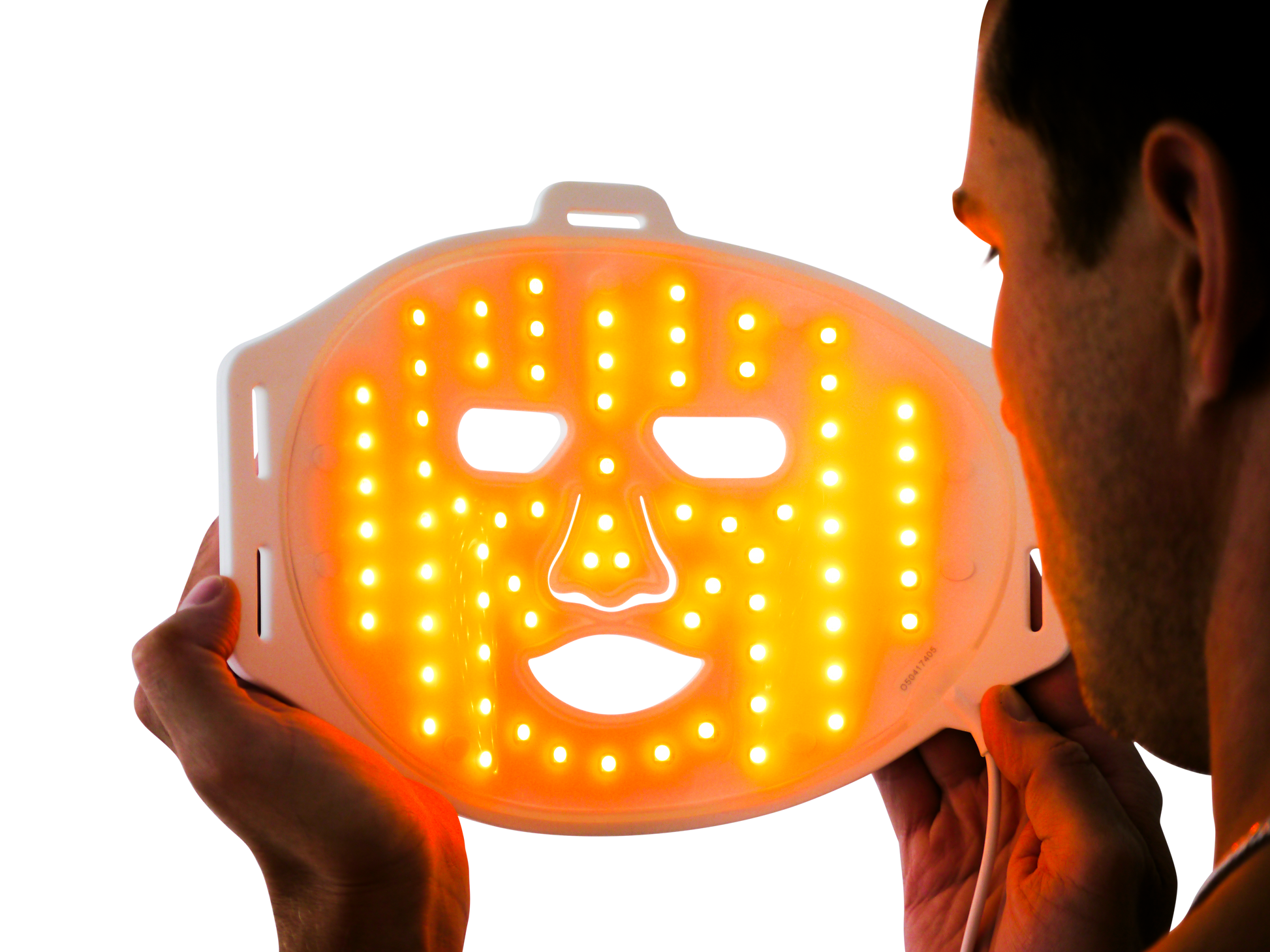 Man holding LED orange light therapy face mask for skin treatment and rejuvenation