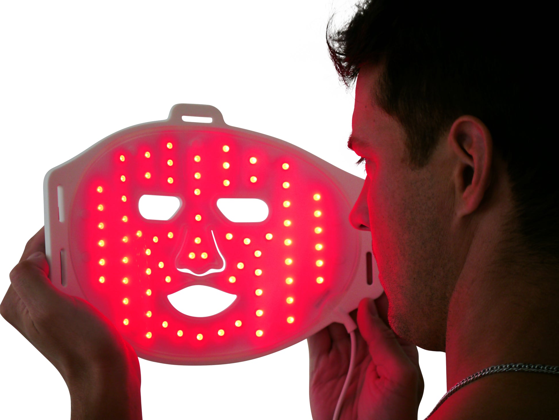 Man holding LED red light therapy face mask for skin rejuvenation and acne treatment